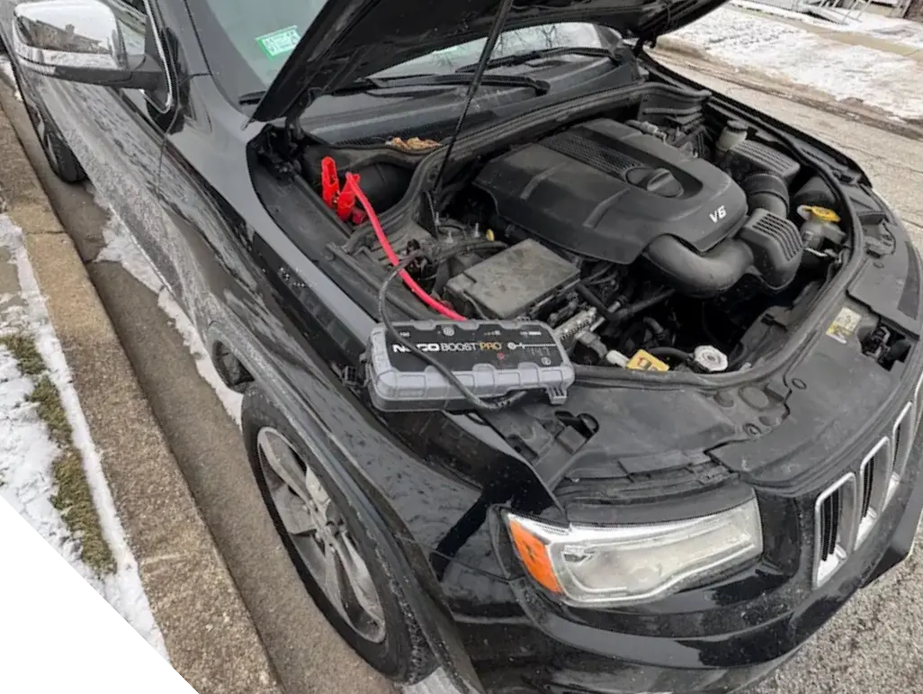 Roadside jump start service in Chicago suburbs using professional battery booster