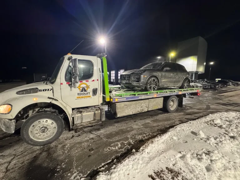 Flatbed towing service in Oak Lawn, IL loading a vehicle at night by Roadlift Towing & Recovery